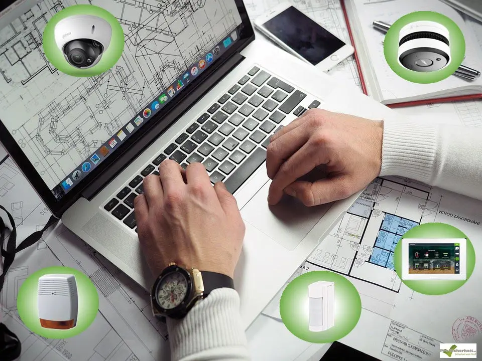 Planung Planung einer Alarmanlage mit Gebäudeplänen am Laptop – Kamera, Rauchmelder, Sirene, Bewegungsmelder und Bedienteil